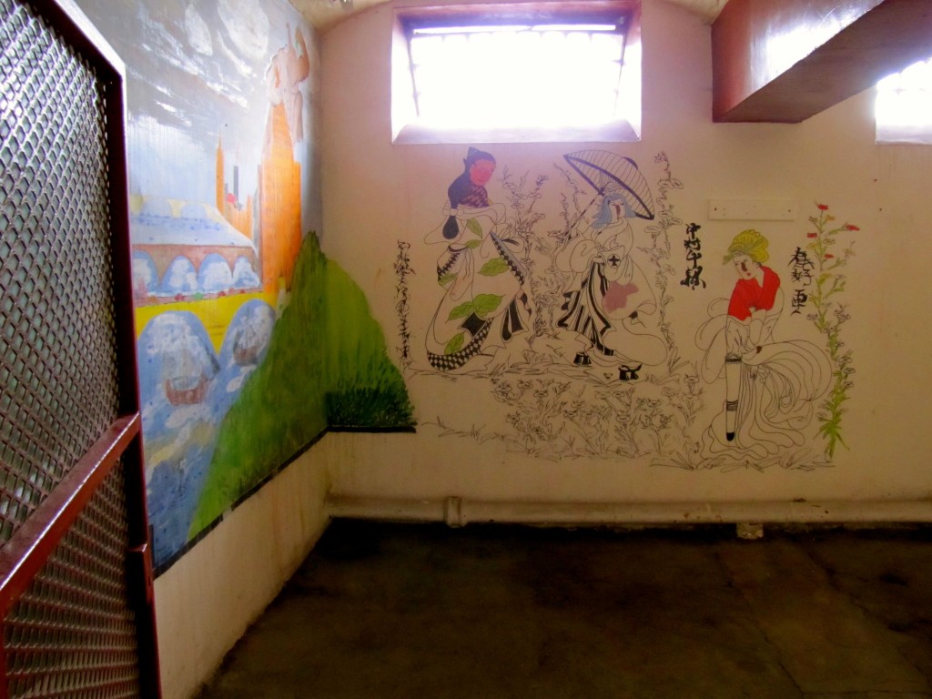 At some point, they knocked the wall out of between two cells to make a larger room for use as an art classroom. Some of the murals have been preserved.