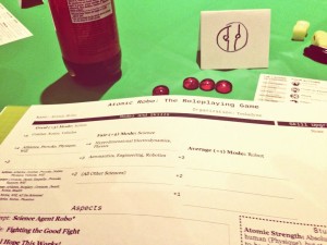 Here's a glimpse of the Atomic Robo character sheet. Note my poor attempt at drawing Robo's head on my little tent card.